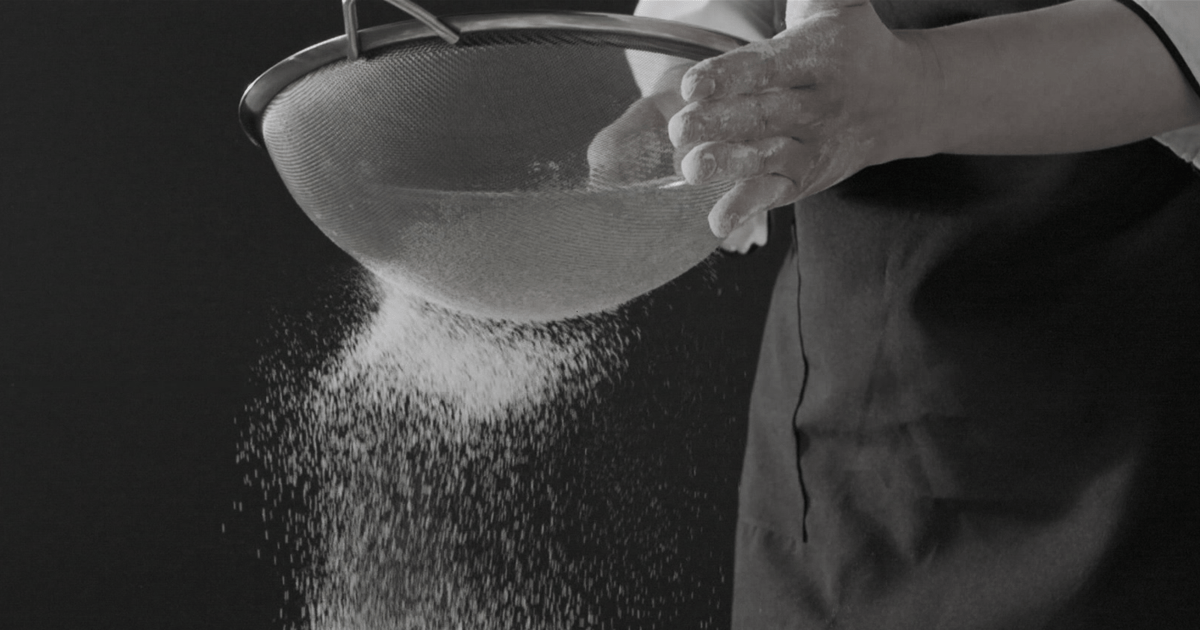 Chef cooking with flour pouring in slow motion